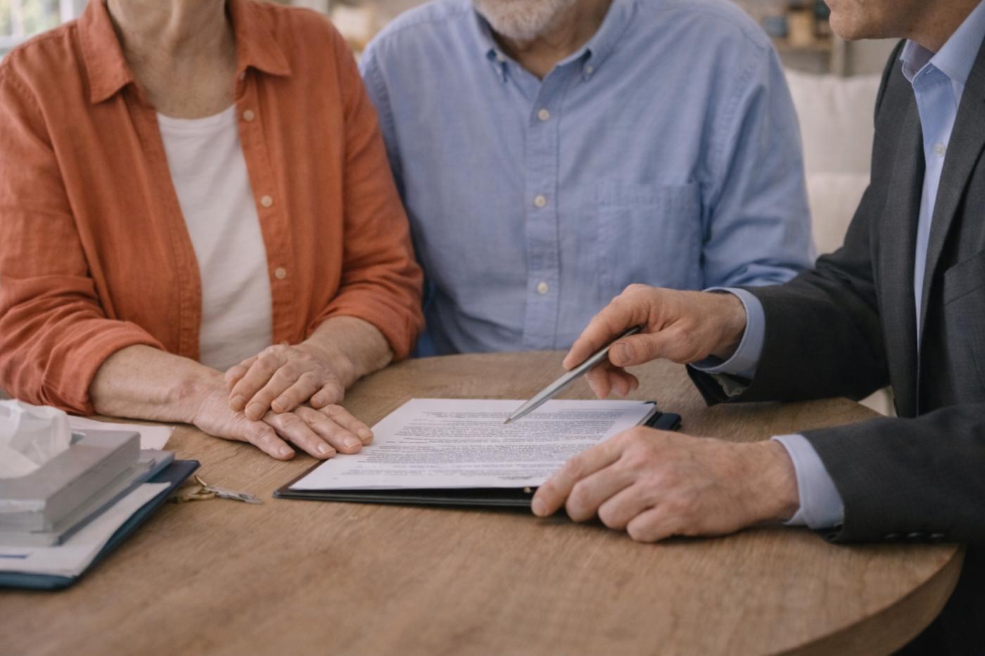 Family meeting with a funeral professional reviewing paperwork and planning arrangements at a table, representing compassionate guidance and cremation services Seattle WA.